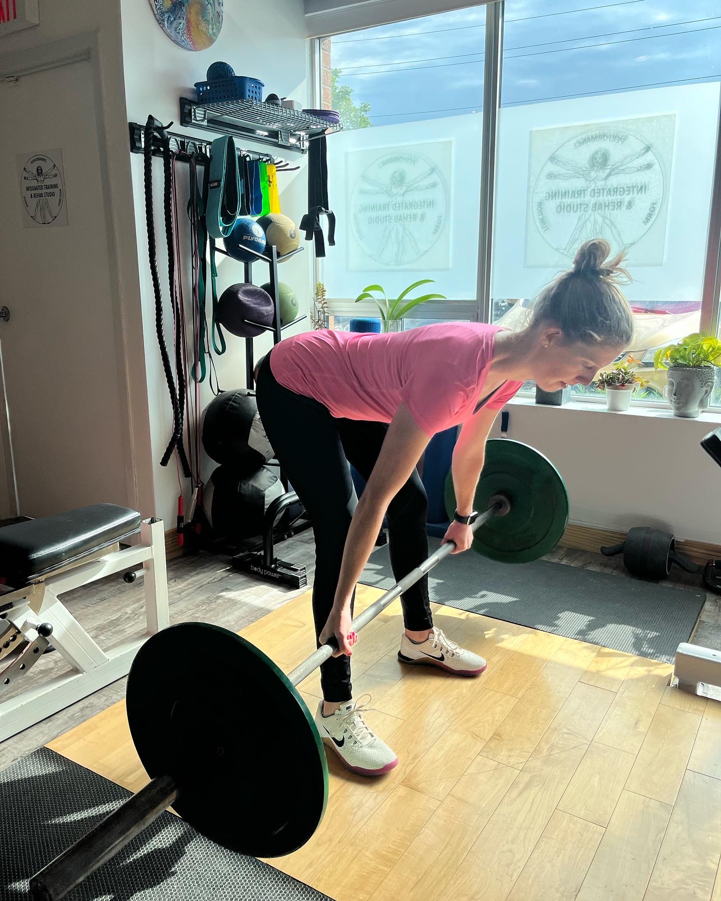 Barbell lift in sunlit studio space